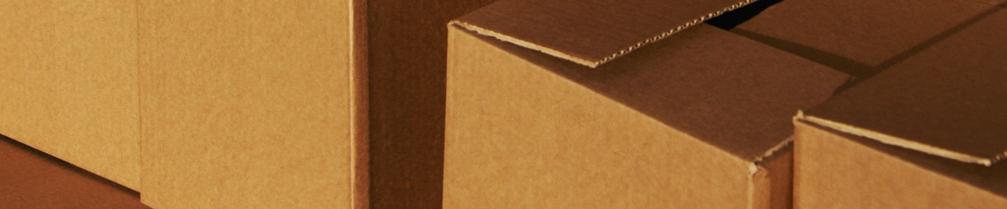 Stacked cardboard boxes ready for shipping or storage in a warehouse setting.